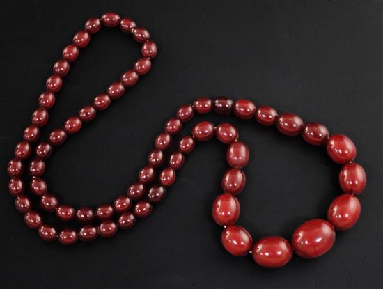 A single strand graduated simulated cherry amber oval bead necklace, 68cm.